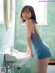 A woman standing in front of a sink in a bathroom.