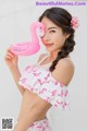 A woman holding a pink flamingo shaped pool float.