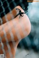 A close up of a woman's butt behind a fence.