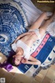 A woman laying on top of a blue and white blanket.