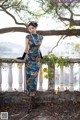 A woman in a blue dress standing on a railing.