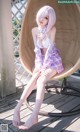 A woman sitting in a wicker chair on a wooden deck.