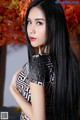 A woman with long black hair posing for a picture.