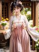 A woman in a pink and white hanbok is posing for a picture.