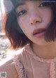 A close up of a woman's face with a pink dress.