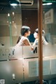 A woman wearing a face mask standing in front of a glass door.