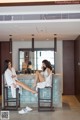 A couple of women sitting on top of a bar.