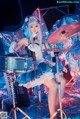 A woman in a blue and white outfit playing a drum set.